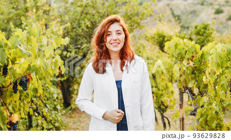 Beautiful agronomist checks the vineyards and smiles at the room Beautiful agronomist checks the vineyards and smiles at the room 93629828