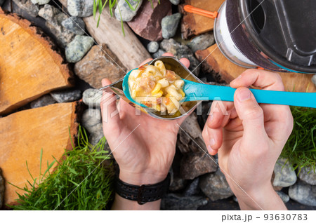 Spoon in hand with food. The tourist holds a spoon with food. Macaroni and cheese dip. Spoon in hand with food. The tourist holds a spoon with food. Macaroni and cheese dip. 93630783