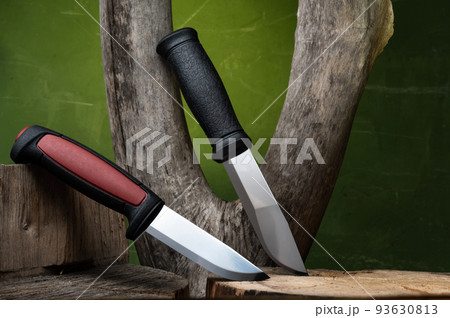 Variety of fixed blade knives. Two knives for hunting and tourism. Knives and dry wood. Composition of knives. Variety of fixed blade knives. Two knives for hunting and tourism. Knives and dry wood. Composition of knives. 93630813