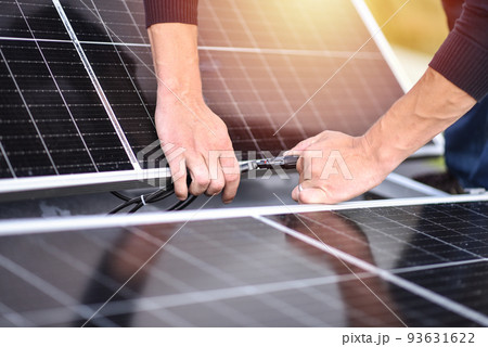 Connecting solar panels to each other. Rooftop solar power system mount, work. Green energy Connecting solar panels to each other. Rooftop solar power system mount, work. Green energy 93631622