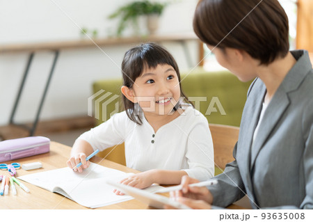 リビングで勉強する小学生の女の子と家庭教師の女性 93635008