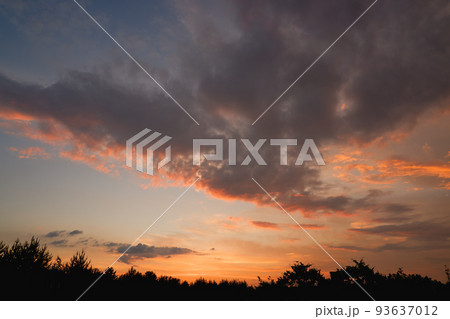 The sky at sunset before bad weather. Low red sunlight illuminates thunderclouds. The sky at sunset before bad weather. Low red sunlight illuminates thunderclouds. 93637012