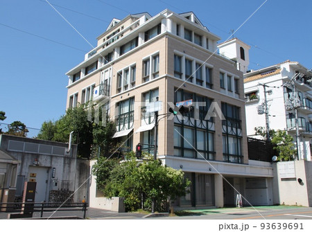 青空に映えるヨーロピアンデザインの三角の切妻屋根と丸柱があるかわいくて美しいオシャレなマンション 93639691