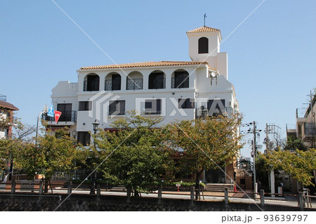 青空に映える尖塔に風見鶏があるクラシカルヨーロピアンの白亜の壁とアイアンの美しいオシャレなマンション 93639797