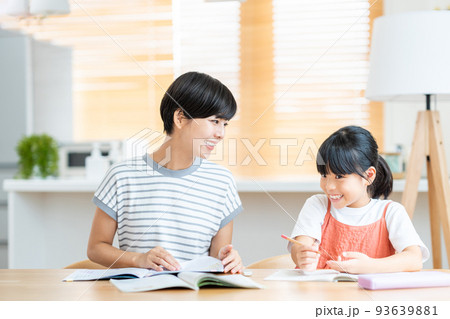 リビングで娘に勉強を教える母親 リビングで娘に勉強を教える母親 93639881
