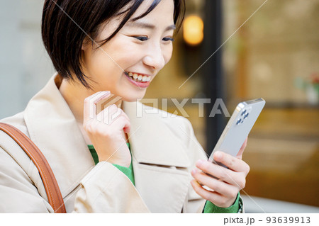 スマホを持つ女性　屋外 93639913