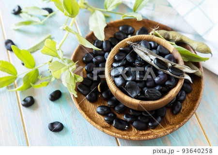 Raw organic vegetables. The concept of vegan or diet food. Fresh ripe black soy beans on a wooden table. Raw organic vegetables. The concept of vegan or diet food. Fresh ripe black soy beans on a wooden table. 93640258