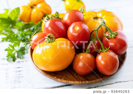 Raw organic vegetables. The concept of vegan or diet food. Fresh ripe bunch colorful tomatoes, red, yellow on a wooden table. 93640263