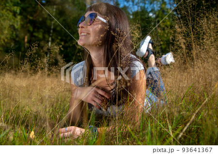 happy carefee young woman lies in grass in sunshining 93641367