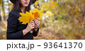 lovely autumn banner. young woman in black holds golden maple leaves in her hands. portrait without face 93641370