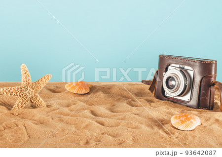 Background of beach with seashells, starfish and a retro photo camera 93642087