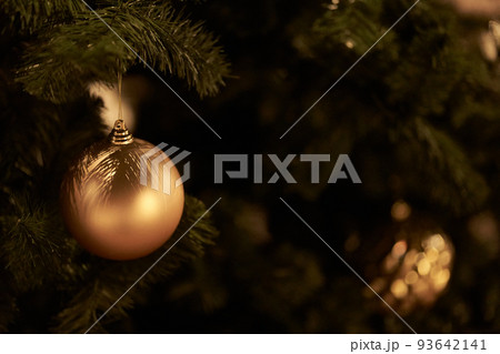 Part of the Christmas tree is decorated with golden balls. The concept of decorating a Christmas tree for the new year. Overlay for your design. High quality photo 93642141