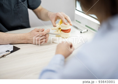 Young woman in consultation with a physical therapist at medical office 93643001