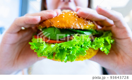 Hamburger vegan healthy vegetarian burger. Salad, avocado, vegetable on veggie sandwich eating cute woman. Tasty vegetarian healthy green food. Hamburger vegan healthy vegetarian burger. Salad, avocado, vegetable on veggie sandwich eating cute woman. Tasty vegetarian healthy green food. 93643728