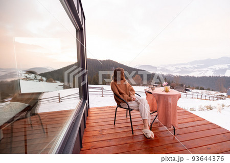 Woman resting at small house in the mountains Woman resting at small house in the mountains 93644376