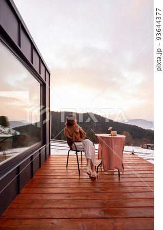 Woman resting at small house in the mountains Woman resting at small house in the mountains 93644377