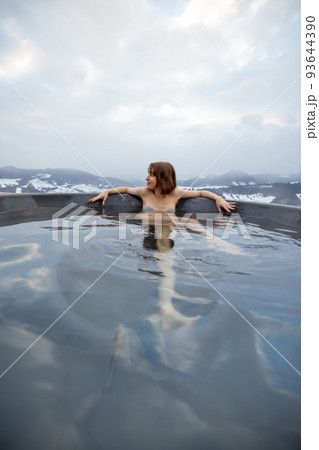 Woman bathing in hot tub at mountains Woman bathing in hot tub at mountains 93644390