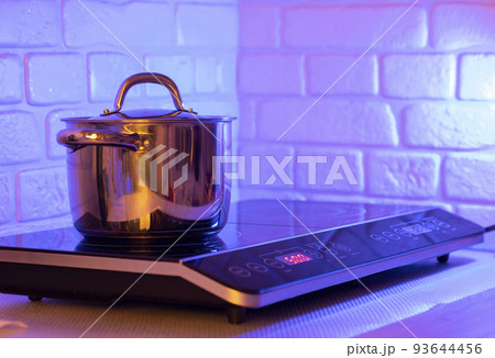 Metal Pot on induction hob in modern kitchen Metal Pot on induction hob in modern kitchen 93644456