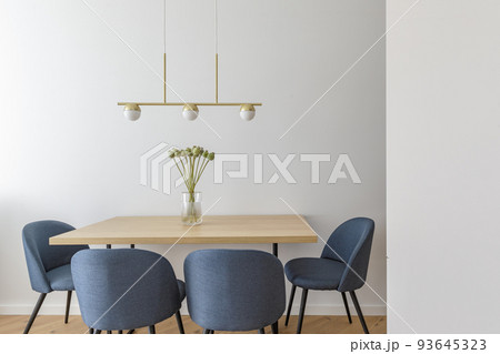 Modern minimalist kitchen and dining room interior design  with wooden furniture, oak floor. blue chairs.  Aesthetic simple interior design concept. 93645323