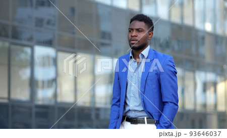 African American man in blue blazer walks past building African American man in blue blazer walks past building 93646037