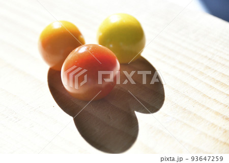 朝陽の差すテーブルの上に置かれたミニトマトを物撮り 93647259
