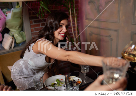 Celebrating with glasses of alcohol in hands. Happy female friends having good time. 93647718