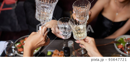 Celebrating with glasses of alcohol in hands. Happy female friends having good time. 93647721