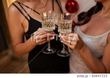 Celebrating with glasses of alcohol in hands. Happy female friends having good time. 93647723