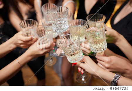 Celebrating with glasses of alcohol in hands. Happy female friends having good time. 93647725
