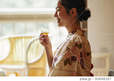 旅館でゆっくりお酒を飲む女性 93648107
