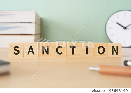 認可・承認・制裁のイメージ｜SANCTIONと書かれたブロックが置かれたデスク 93648190