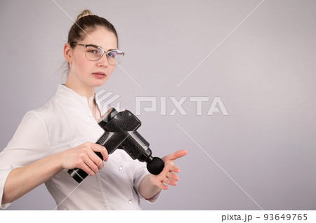 The masseur doctor holds a masseur gun on a...の写真素材 [93649765] - PIXTA