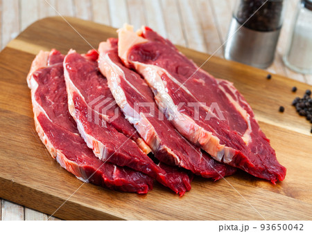 close up of pieces of striploin on wooden table close up of pieces of striploin on wooden table 93650042