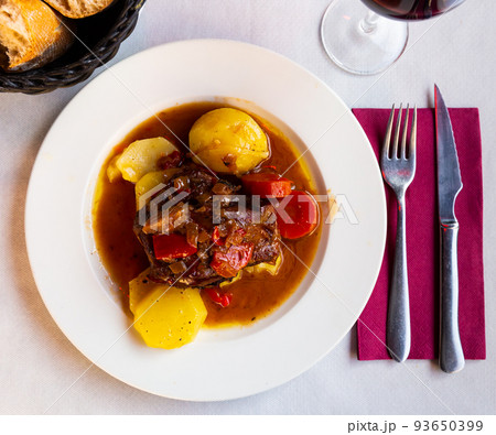 Appetizing lamb shoulder baked with potatoes and stewed vegetables Appetizing lamb shoulder baked with potatoes and stewed vegetables 93650399