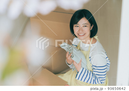 ダンボールに衣類を仕舞う女性 ダンボールに衣類を仕舞う女性 93650642