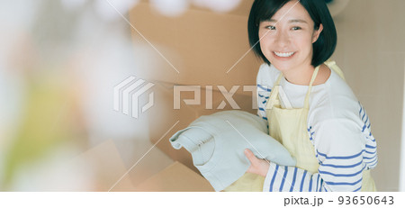 ダンボールに衣類を仕舞う女性 ダンボールに衣類を仕舞う女性 93650643