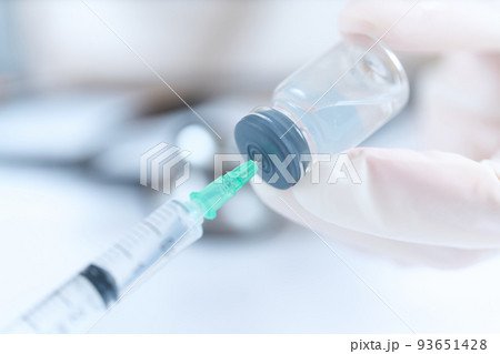バイアル瓶から注射薬を吸う医師の手元 バイアル瓶から注射薬を吸う医師の手元 93651428