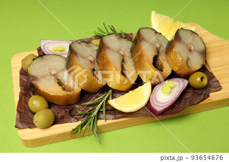 Concept of tasty food with smoked mackerel on green background 93654676