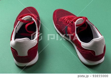 Pair of red sport shoes on green background. 93655000
