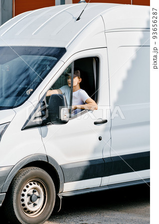 Young courier woman driving a van 93656287