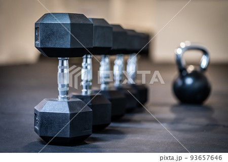Row of dumbbell exercise weights on the floor 93657646