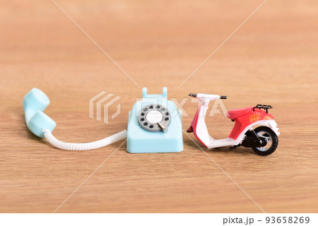 玩具の壊れたバイクと受話器が外れたアナログ電話機 玩具の壊れたバイクと受話器が外れたアナログ電話機 93658269