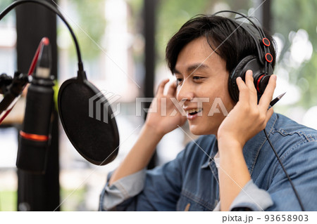 Asian male podcaster making audio podcast from her home studio 93658903