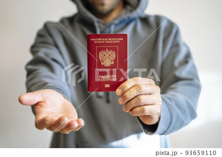 Russian passport in the hands of a man. Prohibition of Schengen visas for Russian tourists to travel to the European Union concept. Russian passport in the hands of a man. Prohibition of Schengen visas for Russian tourists to travel to the European Union concept. 93659110