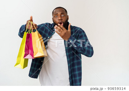 Happy african american man holding shopping bags on white background. Holidays concept Happy african american man holding shopping bags on white background. Holidays concept 93659314