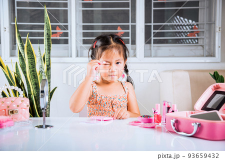 little girl making makeup her face she applying carborundum eyeliner to eyelid little girl making makeup her face she applying carborundum eyeliner to eyelid 93659432