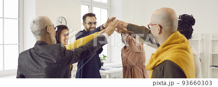 Business people who are inspired by fruitful cooperation join hands in unity and teamwork. 93660303