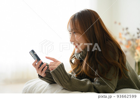 スマホを見る日本人女性 横顔 コピースペースあり 秋冬ニット スマホを見る日本人女性 横顔 コピースペースあり 秋冬ニット 93662599