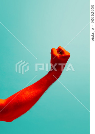 The threat. Man's hand clenched into fist isolated on light blue background in red neon light. Concept of relationship, community, care, support, symbolism, culture The threat. Man's hand clenched into fist isolated on light blue background in red neon light. Concept of relationship, community, care, support, symbolism, culture 93662659