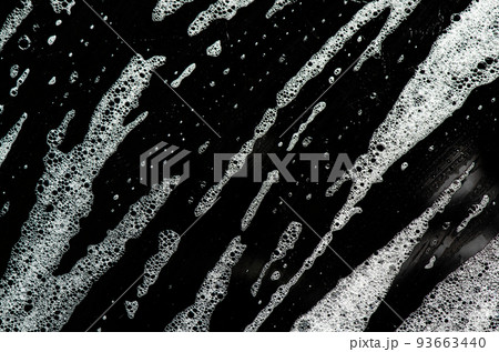 Texture of white foam on a black background. Cleansing mousse for the face or shaving foam or washing powder. Closeup 93663440